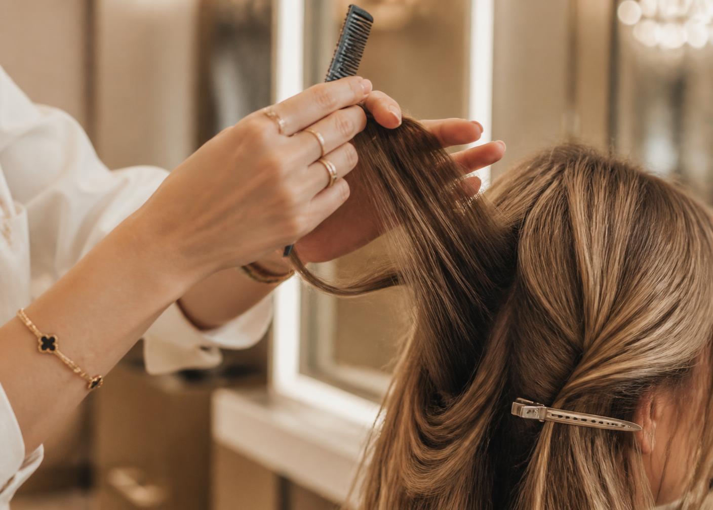 Üst segment bir güzellik salonunda müşterinin saçıyla ilgilenen kuaför